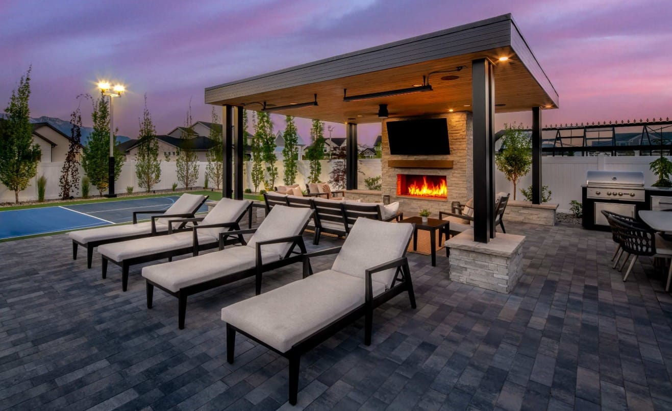 A custom designed backyard with a luxury pergola and three elegant chaise lounge chairs in front of it.